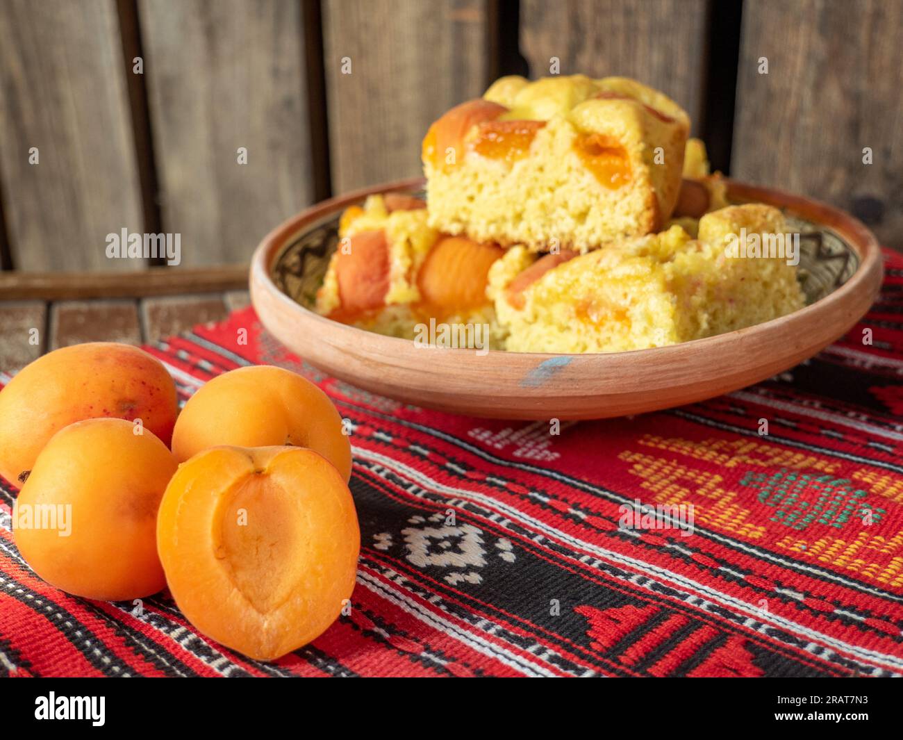 torta di spugna di albicocca fatta in casa su un tradizionale panno rosso rumeno Foto Stock