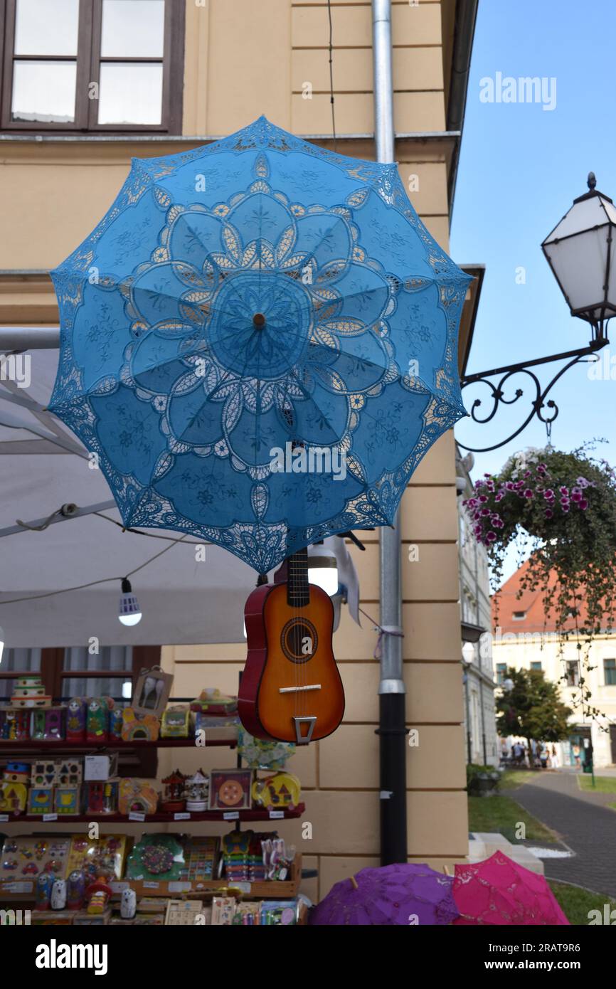 Chitarra marrone-rossa brillante appesa a una fiera di strada Foto Stock