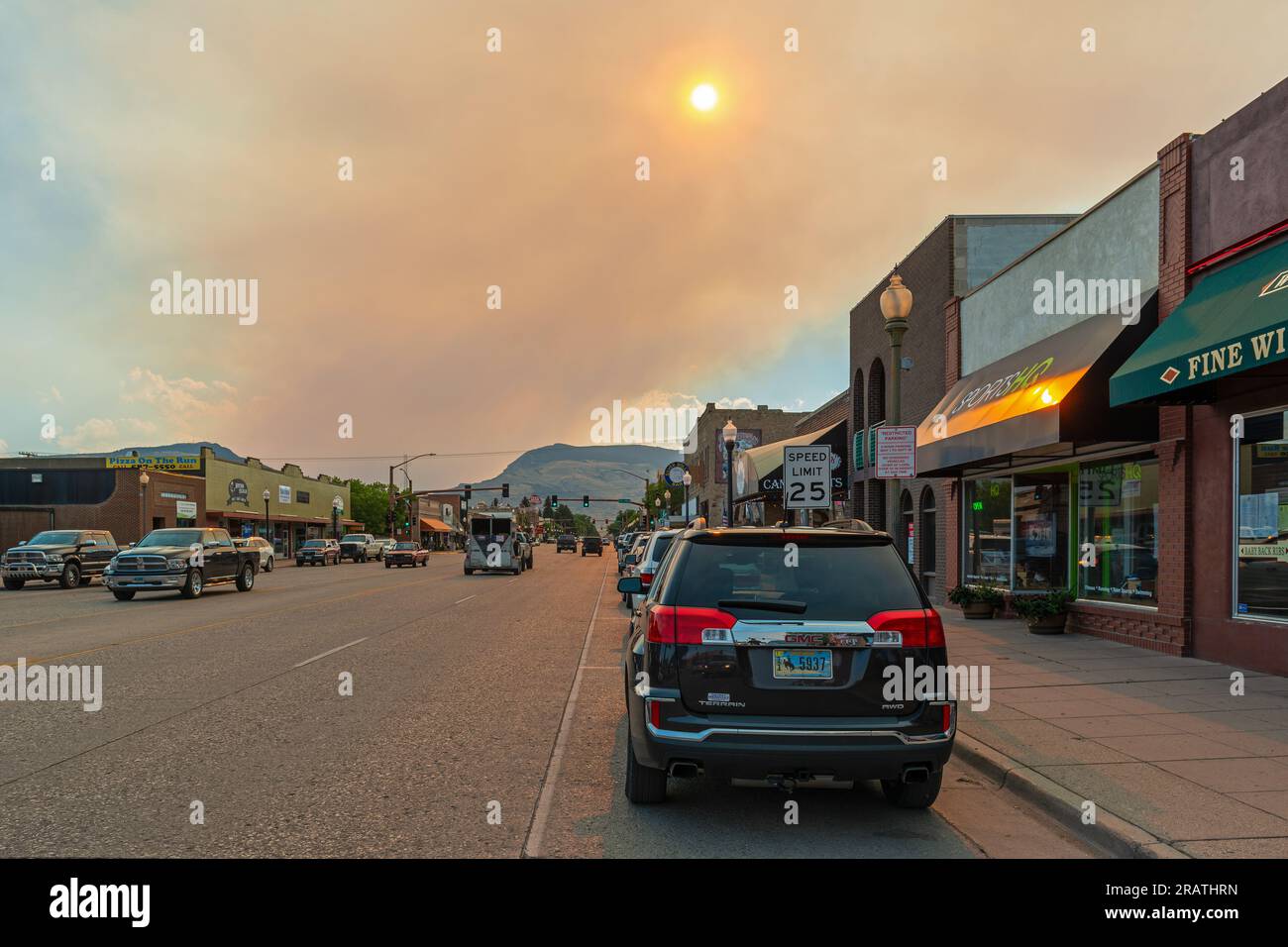 Gli incendi fumano nel parco nazionale di Yellowstone visto dal centro di Cody City al tramonto, Wyoming, USA. Foto Stock