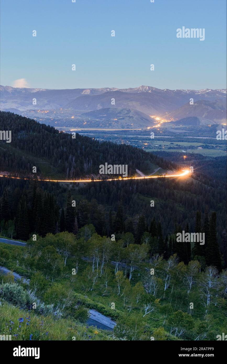 Sentieri leggeri che attraversano la montagna dai fari delle auto che salgono sull'autostrada 22 sopra Jackson Hole. Bridger-Teton National Forest, Wyoming Foto Stock