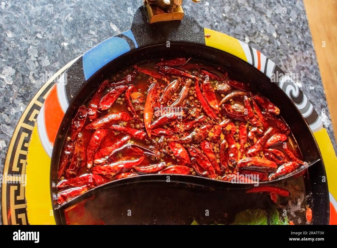 Vista dall'alto di una parte della zuppa di peperoncino molto piccante in una pentola calda. Un tavolo con deliziosi piatti caldi. Foto Stock