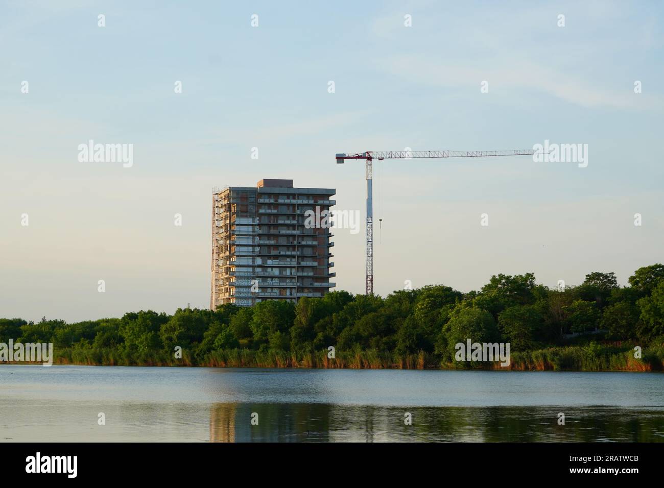 Complesso di appartamenti in costruzione e gru alta sulla riva del lago Fundeni a Bucarest Foto Stock