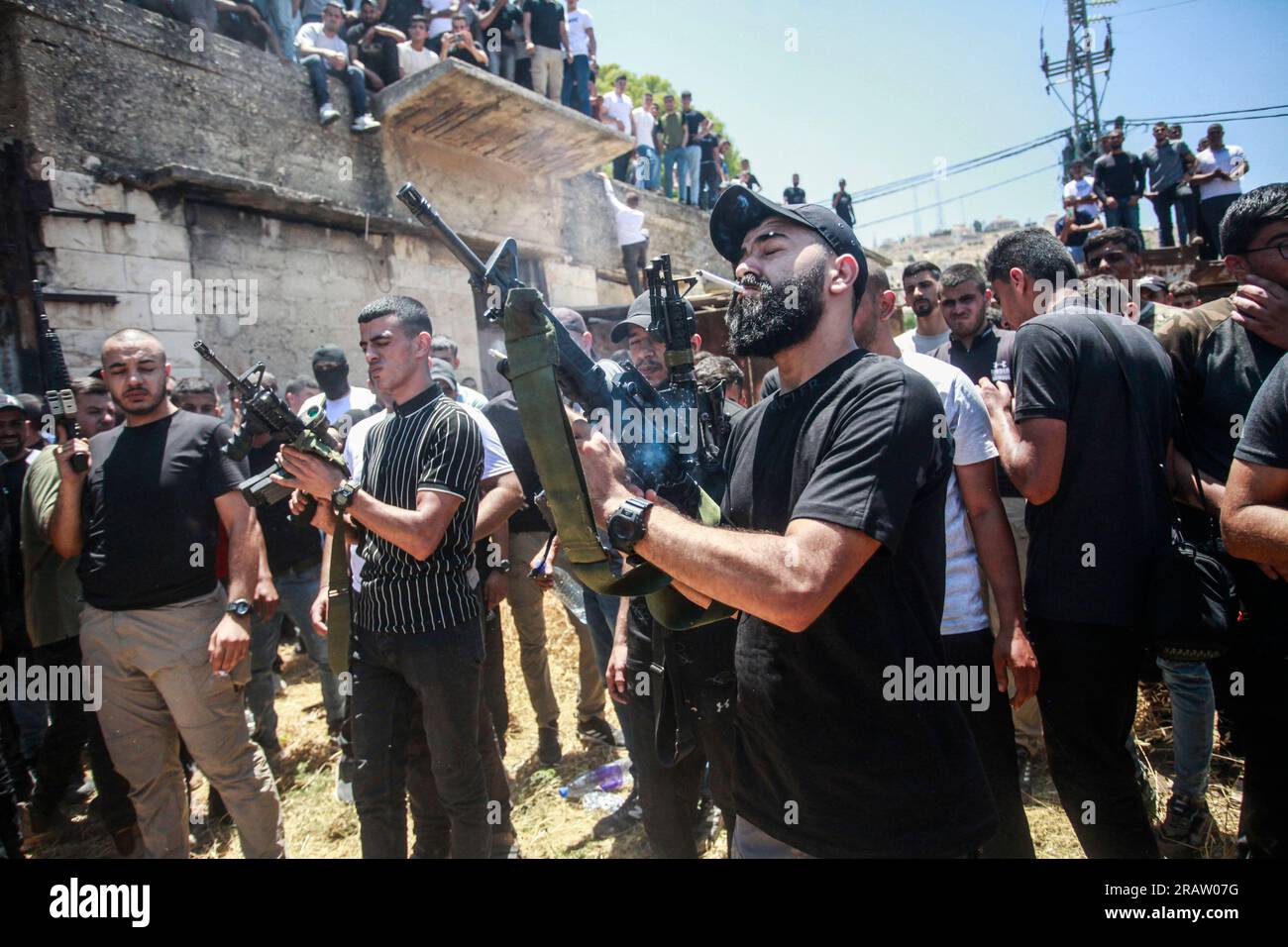 Jenin, Palestina. 5 luglio 2023. Uomini armati palestinesi sparano in aria durante i funerali dei palestinesi uccisi dai proiettili dell'esercito israeliano nel campo profughi di Jenin, in Cisgiordania. L'esercito israeliano afferma di aver ritirato le proprie truppe dal campo mercoledì, ponendo fine a un'intensa operazione di due giorni che ha ucciso almeno 13 palestinesi, ha allontanato migliaia di persone dalle loro case e ha lasciato un'ampia serie di danni sulla scia. Anche un soldato israeliano è stato ucciso. (Foto di Nasser Ishtayeh/SOPA Images/Sipa USA) credito: SIPA USA/Alamy Live News Foto Stock