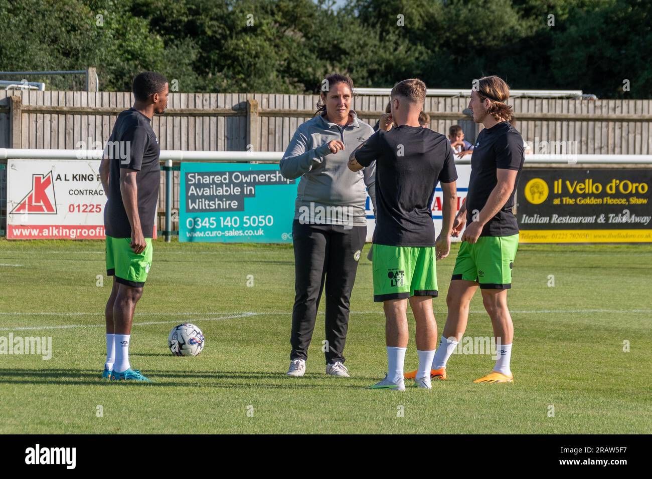 Hannah Dingley, prima manager donna di una squadra maschile di calcio inglese, dà indicazioni a 3 giovani giocatori Forest Green Rover durante il riscaldamento della loro partita di pre-stagione con il Melksham Town FC Foto Stock