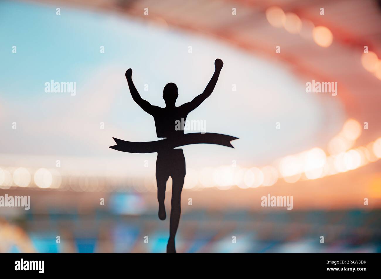 Il corridore sagomato rompe il nastro al Modern Athletics Stadium. Una potente immagine di gara su pista e campo piena di trionfo. Foto Stock