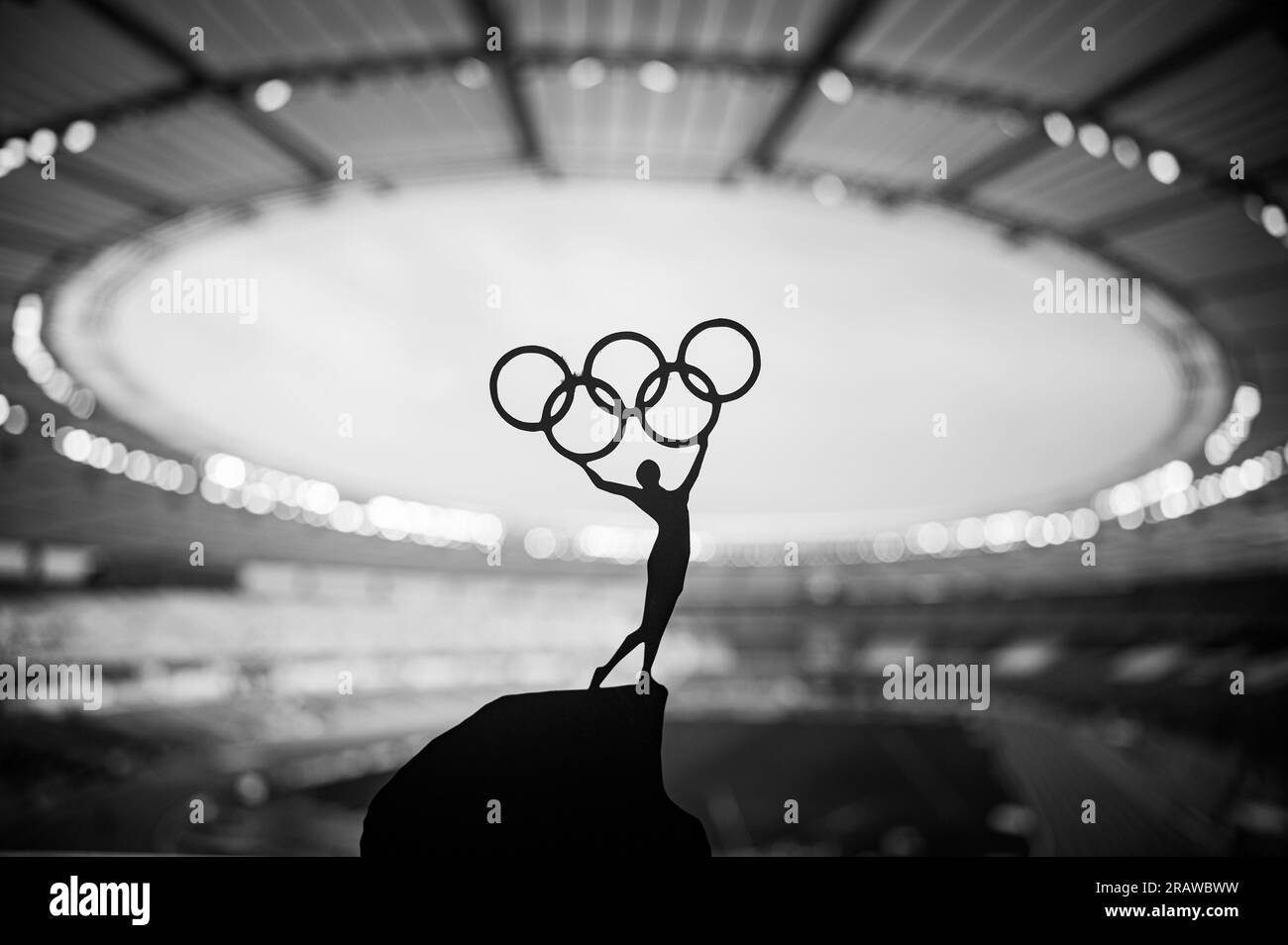 PARIGI, FRANCIA, 7 LUGLIO 2023: Foto in bianco e nero. Spirito Olimpico: La statua dell'atleta tiene l'Olympic Circle High presso il moderno Stadio Olimpico. Acquisizione di t Foto Stock