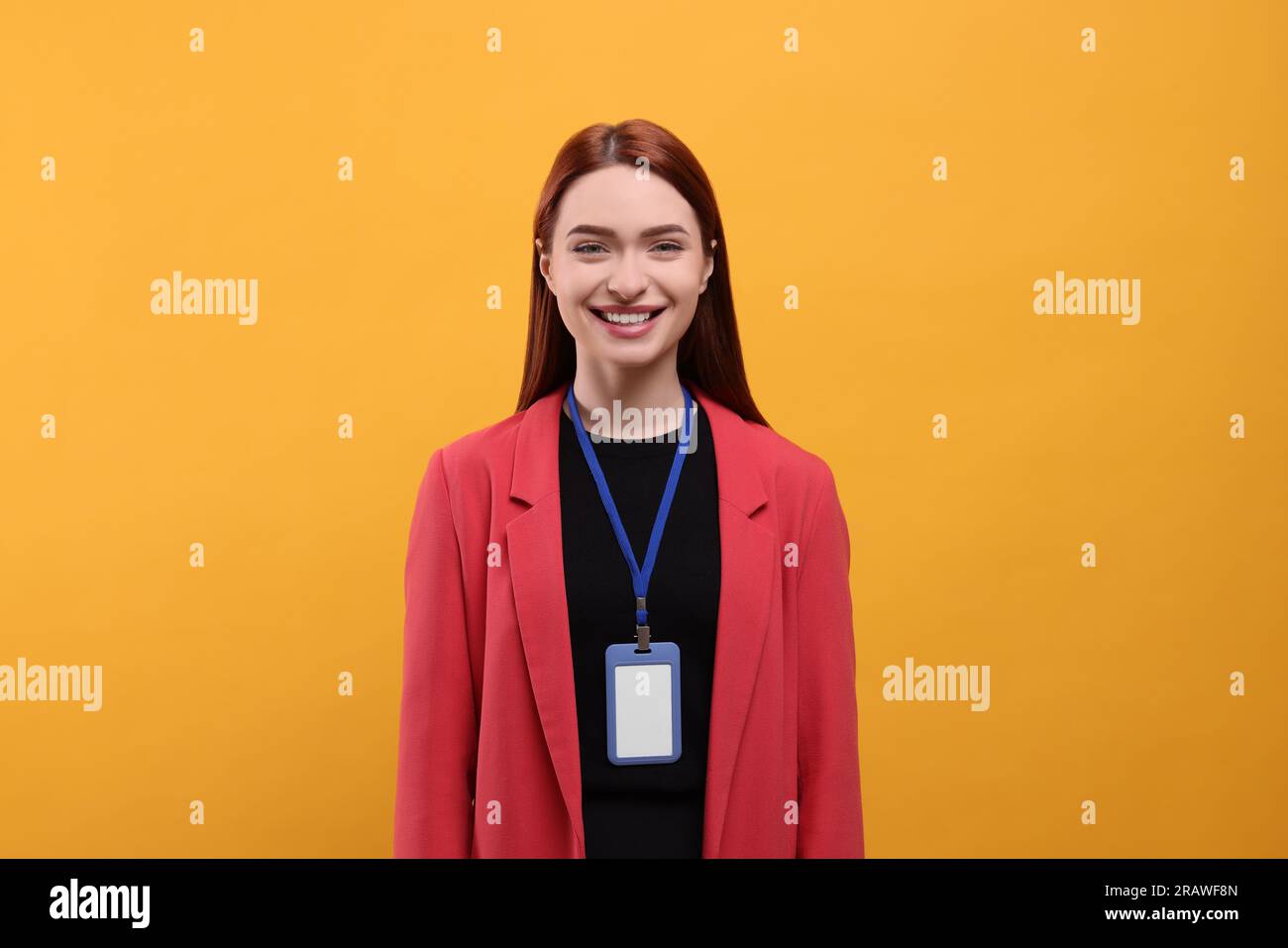 Donna sorridente con badge vip pass su sfondo arancione Foto Stock Donna sorridente con badge vip pass su sfondo arancione Foto Stock