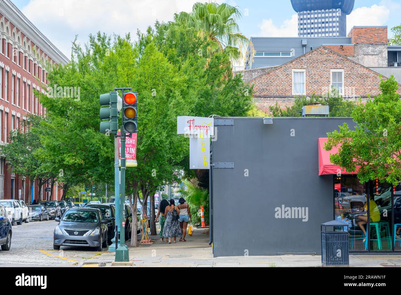 NEW ORLEANS, LOUISIANA, USA - 2 LUGLIO 2023: Angolo del Flamingo A-Go-Go ristorante e bar nel Warehouse District con turisti ed edifici circostanti Foto Stock