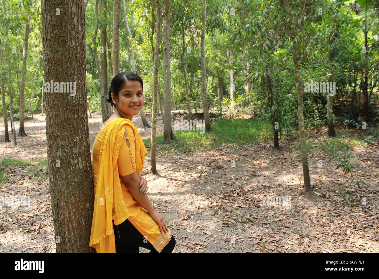 Ritratto di giovane ragazza asiatica/indiana che indossa il giallo salwa kameez e sorride. Foto Stock