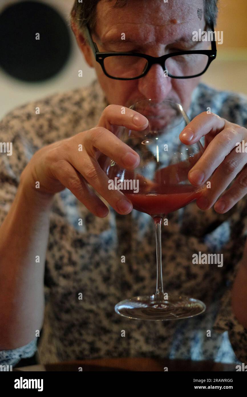Uomo che annusa il succo di frutta in un grande pranzo con bicchiere di vino al ristorante Yellow Vegan di Potts Point. Foto Stock