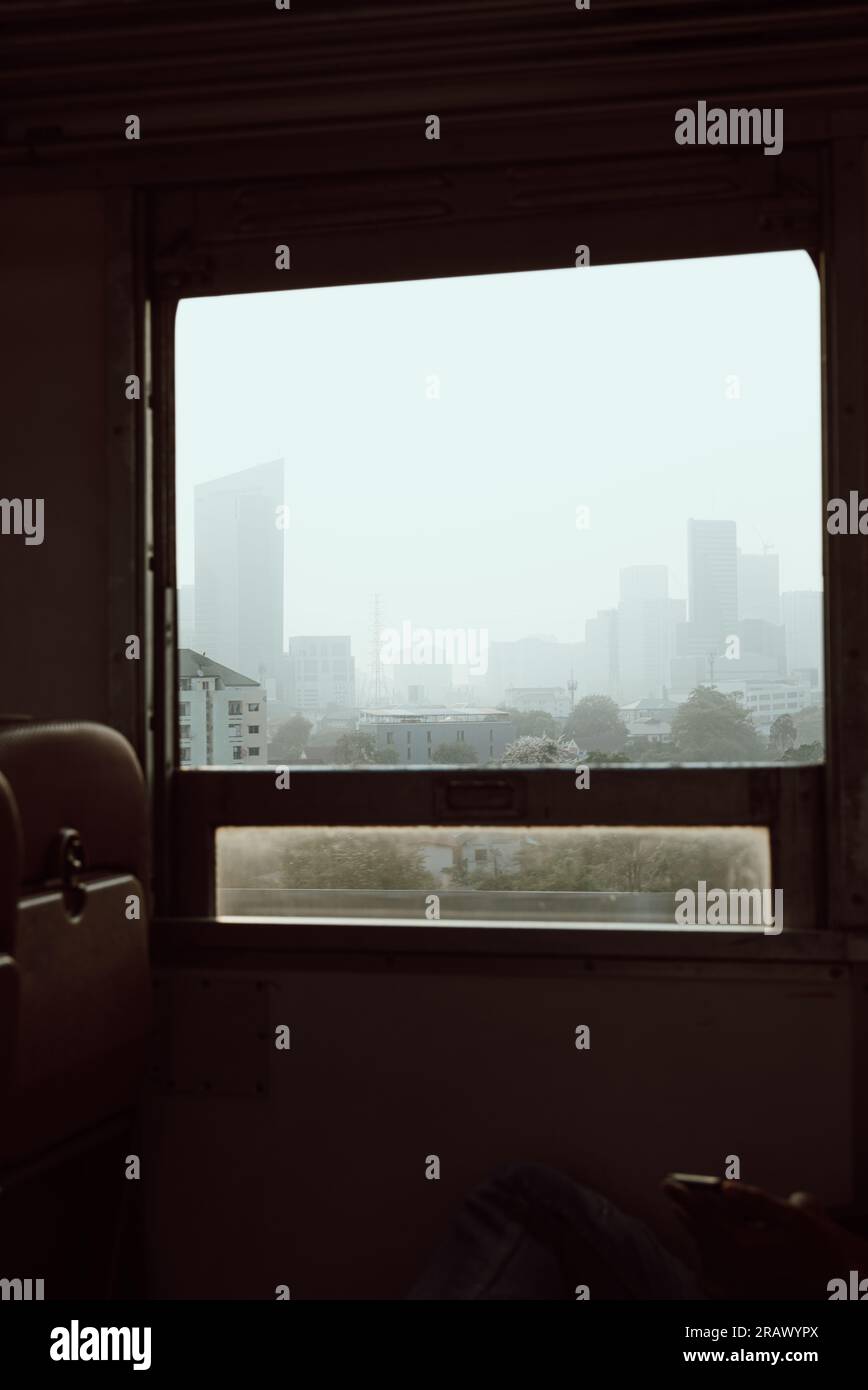 Paesaggio urbano incorniciato da una finestra del treno, rivelando una vista accattivante. Grattacieli. Uno sguardo alla vita urbana Foto Stock
