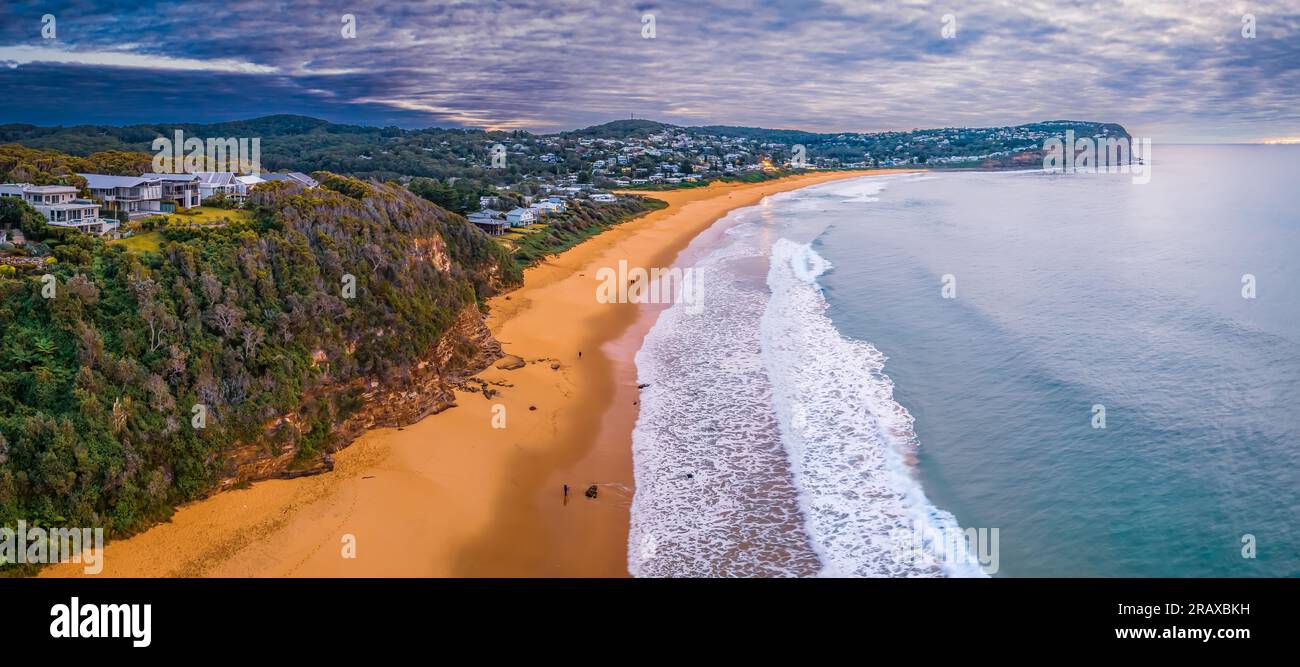 Alba aerea con cielo pieno di nuvole e piccole onde a Macmasters Beach sulla Central Coast, New South Wales, Australia. Foto Stock