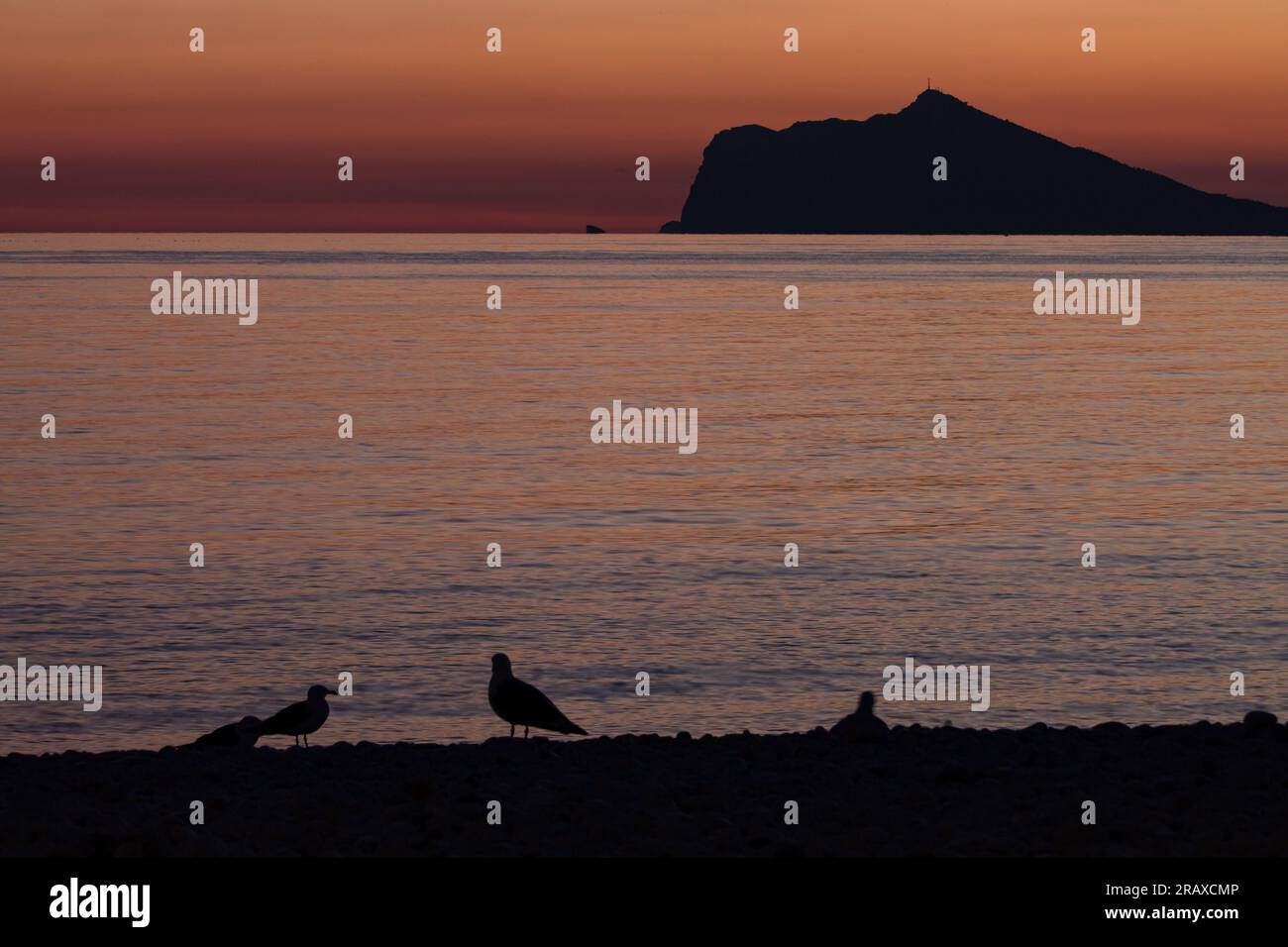 Tramonto da Calpe con la silhouette della Sierra Helada di Benidorm Foto Stock