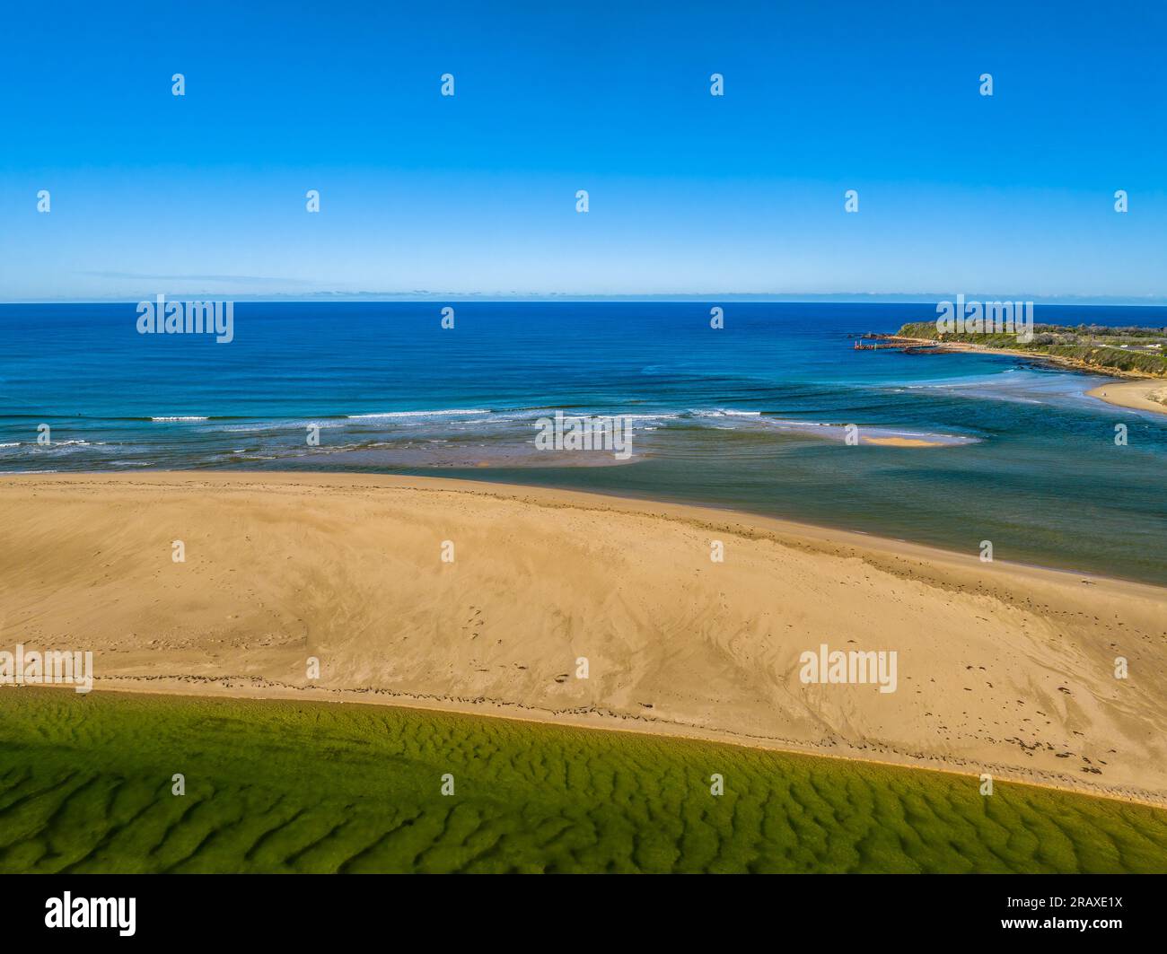 Cielo blu vista diurna della costa sul mare e il fiume Wallagaraugh a Mallacoota, Victoria, Australia Foto Stock