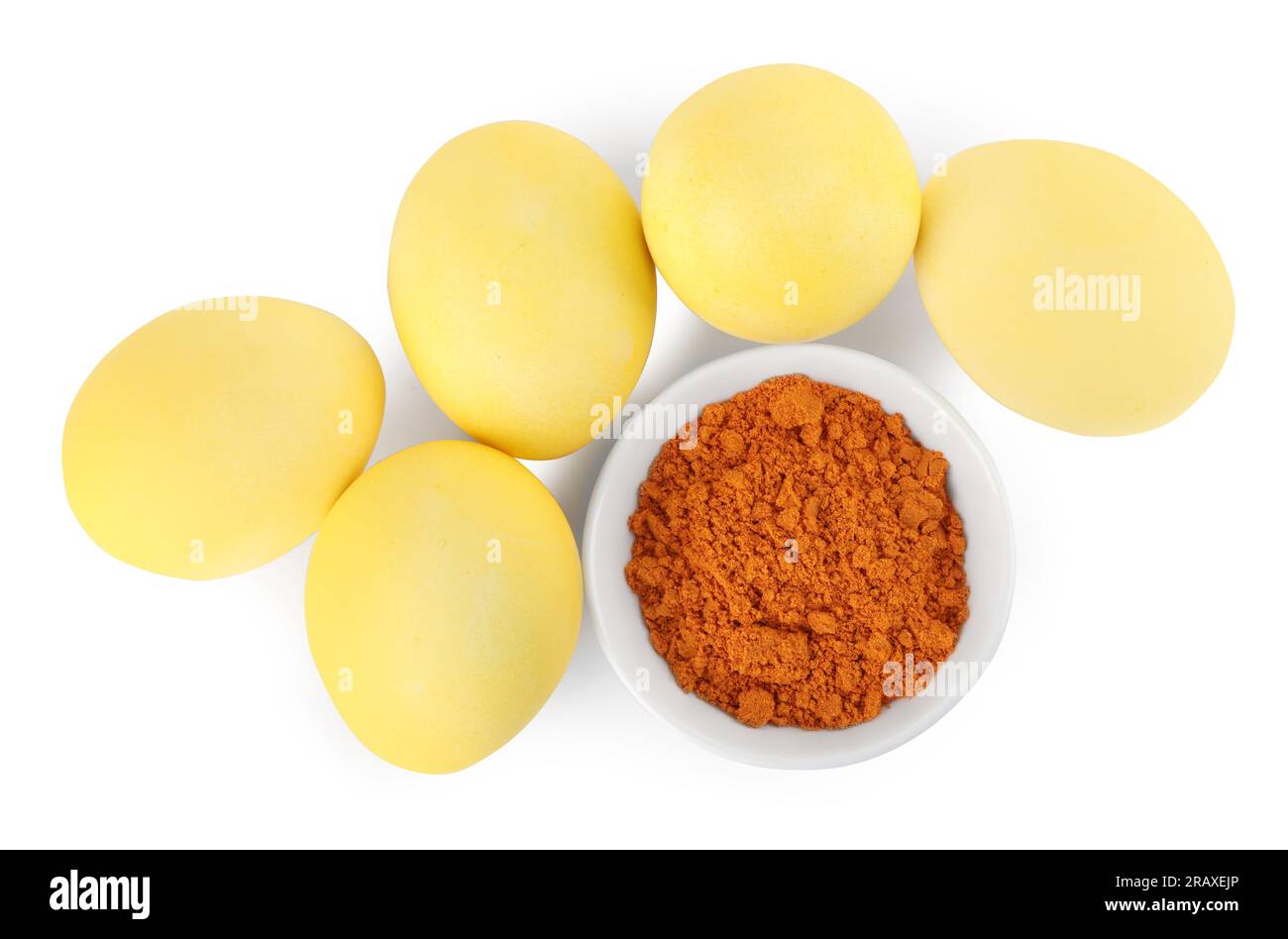 Uova di Pasqua gialle dipinte con colorante naturale e curcuma in polvere in ciotola su sfondo bianco, vista dall'alto Foto Stock