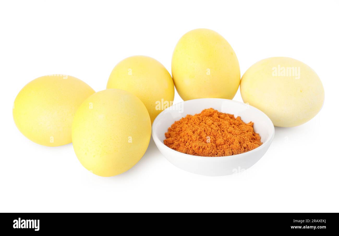 Uova di Pasqua gialle dipinte con colorante naturale e curcuma in polvere in ciotola su sfondo bianco Foto Stock