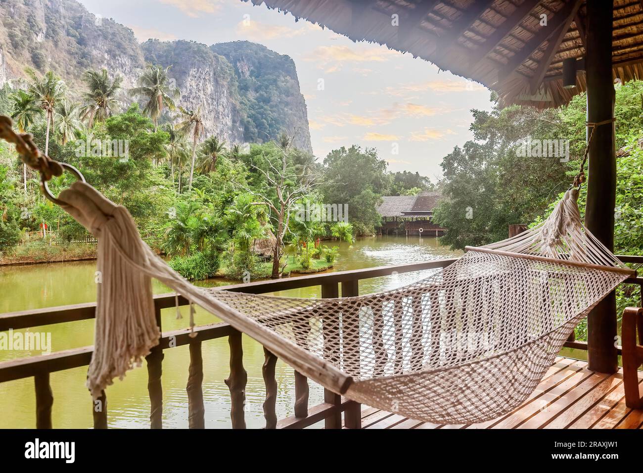 Amaca in una casa di legno con vista sulle montagne e sul lago in un resort naturalistico Foto Stock