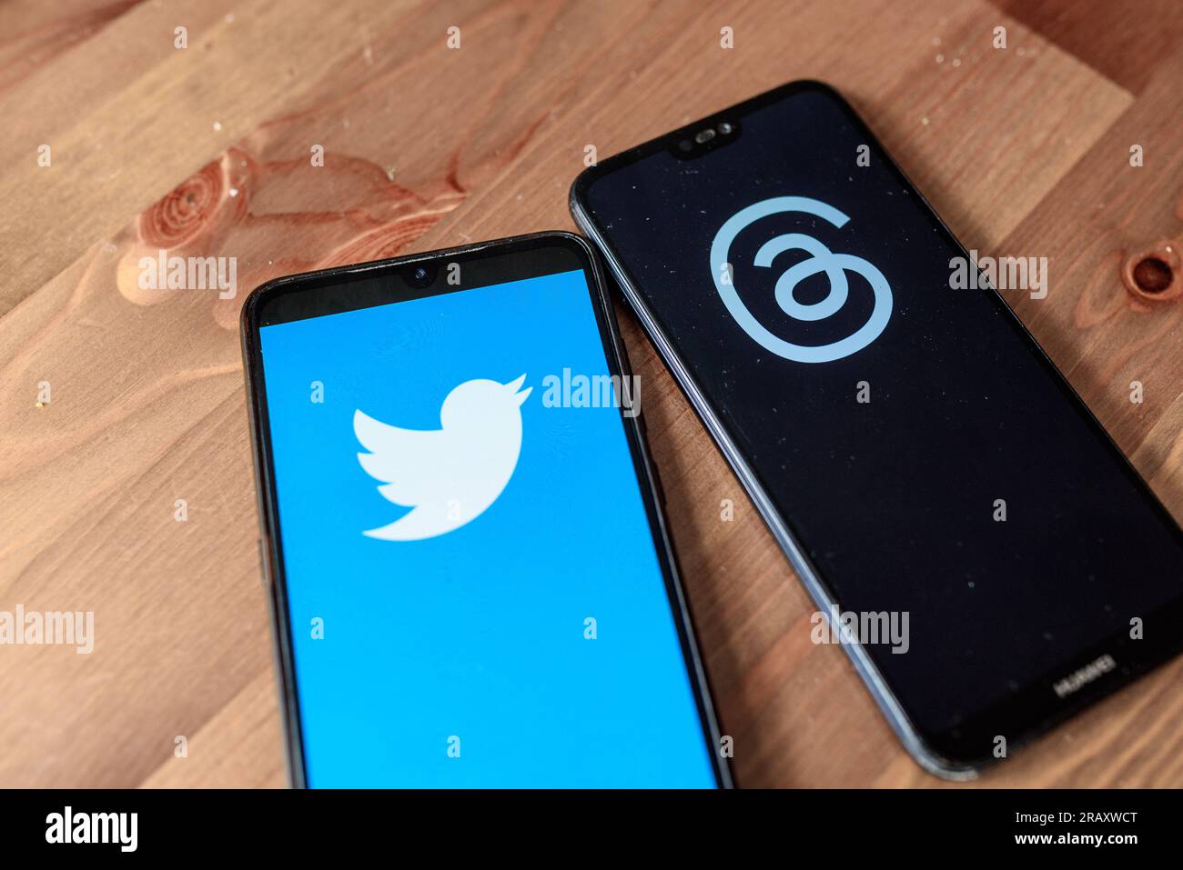 In questa foto, i thread dell'app dal logo Meta e dal logo Twitter sono visibili sul display di due telefoni cellulari su un tavolo. Thread è il Foto Stock