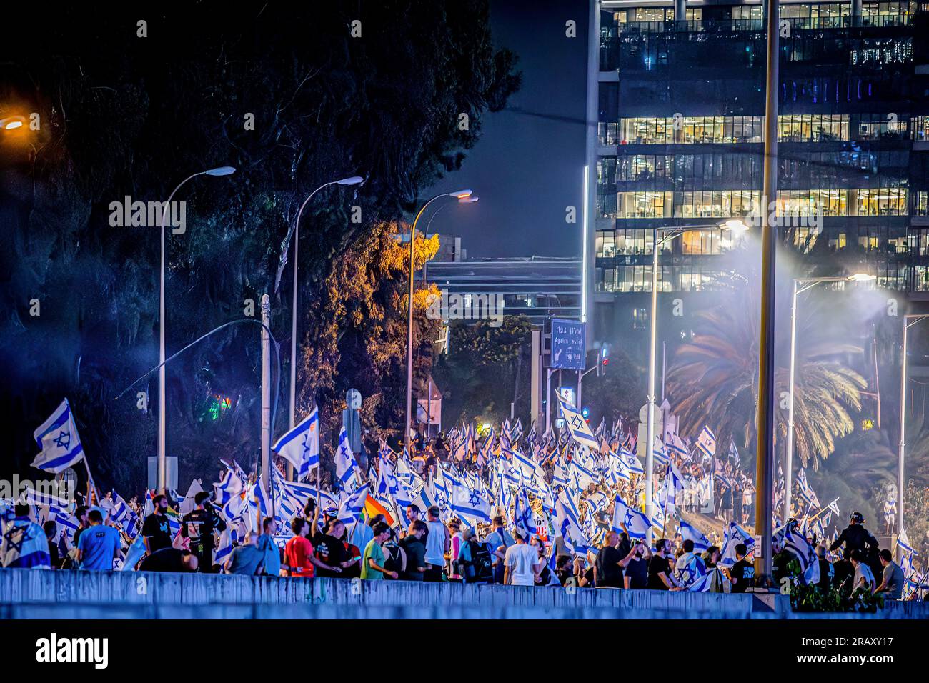 Tel Aviv, Israele. 5 luglio 2023. I manifestanti che sventolano bandiere israeliane bloccano l'autostrada Ayalon durante una dimostrazione. Migliaia di manifestanti bloccarono l'autostrada principale di Tel Aviv, le strade principali e gli incroci attraverso Israele in uno spontaneo sfogo di rabbia a seguito delle dimissioni forzate del popolare capo della polizia della città. Credito: SOPA Images Limited/Alamy Live News Foto Stock