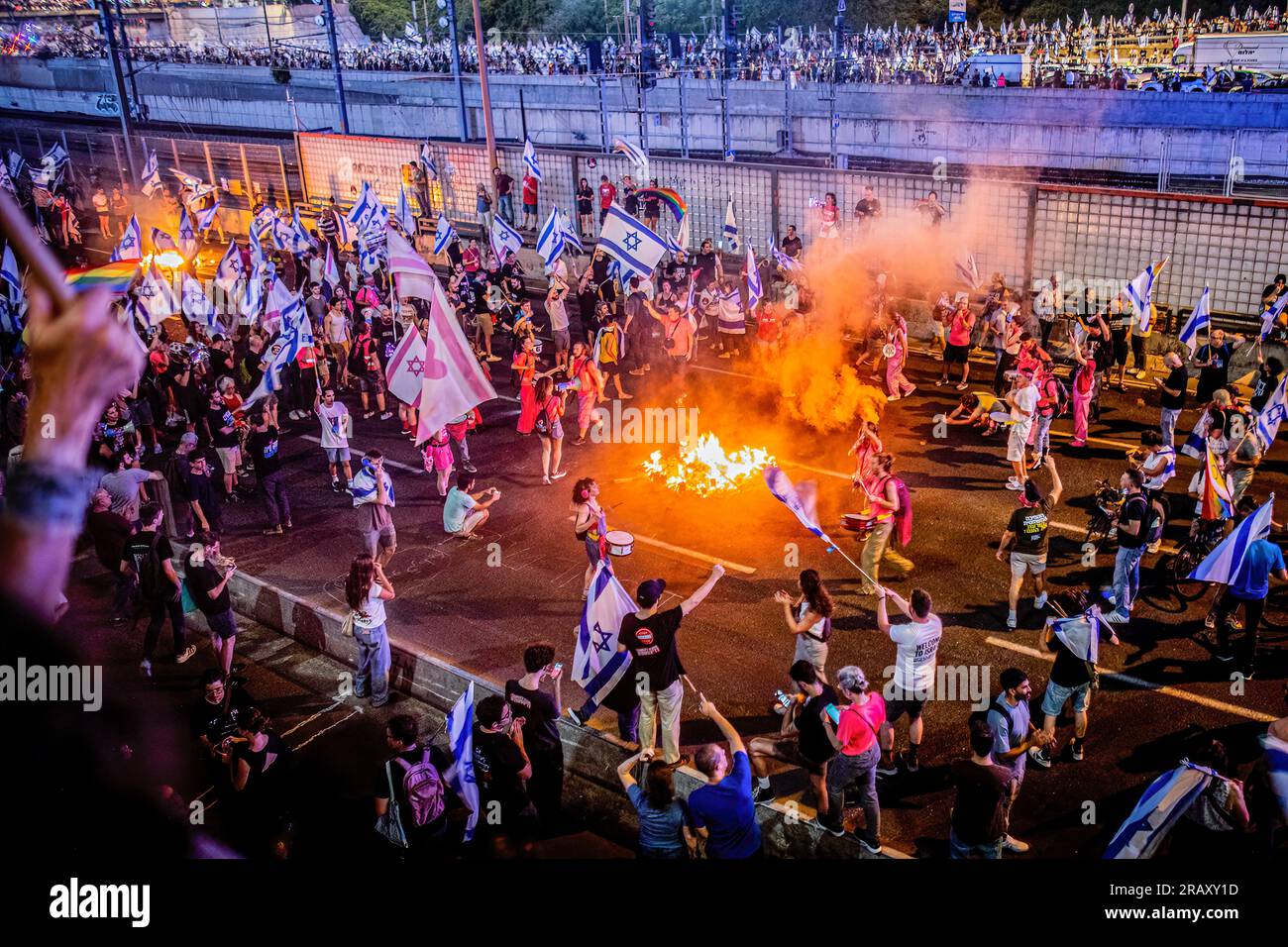 Tel Aviv, Israele. 5 luglio 2023. I manifestanti che sventolano bandiere israeliane bloccano l'autostrada Ayalon durante una dimostrazione. Migliaia di manifestanti bloccarono l'autostrada principale di Tel Aviv, le strade principali e gli incroci attraverso Israele in uno spontaneo sfogo di rabbia a seguito delle dimissioni forzate del popolare capo della polizia della città. Credito: SOPA Images Limited/Alamy Live News Foto Stock