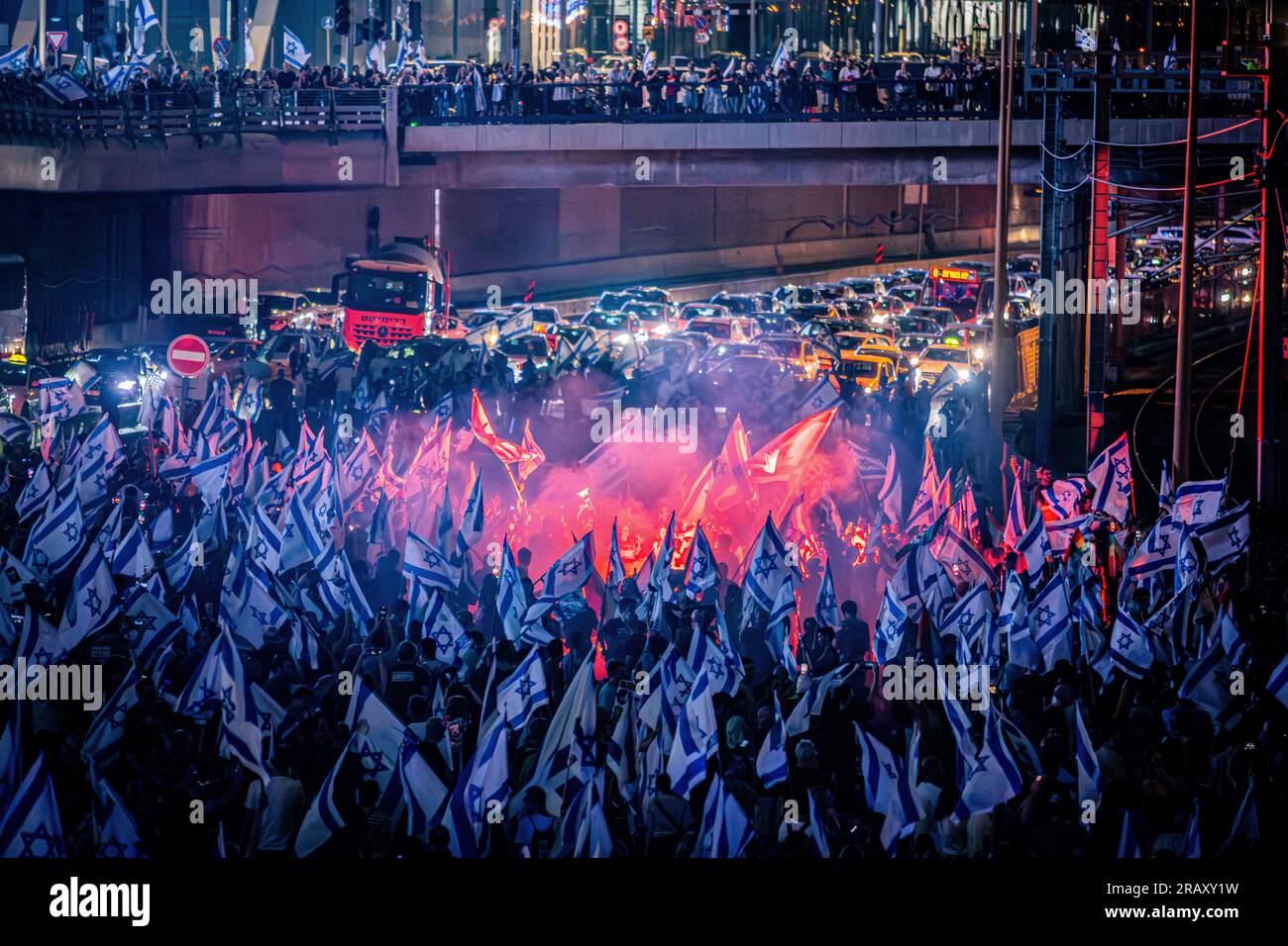 Tel Aviv, Israele. 5 luglio 2023. I manifestanti che sventolano bandiere israeliane bloccano l'autostrada Ayalon durante una dimostrazione. Migliaia di manifestanti bloccarono l'autostrada principale di Tel Aviv, le strade principali e gli incroci attraverso Israele in uno spontaneo sfogo di rabbia a seguito delle dimissioni forzate del popolare capo della polizia della città. Credito: SOPA Images Limited/Alamy Live News Foto Stock