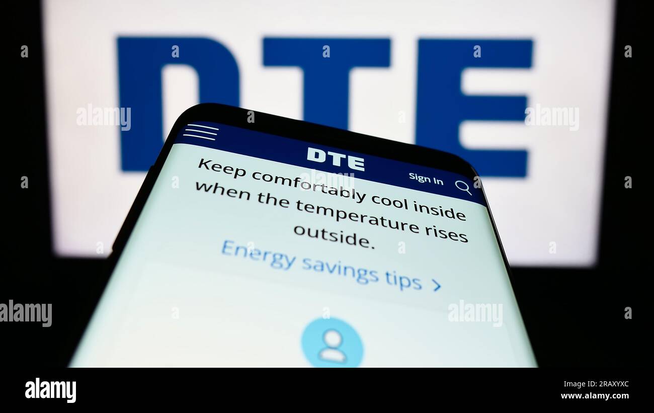 Telefono cellulare con sito Web della società di servizi pubblici statunitense DTE Energy Co. Sullo schermo davanti al logo aziendale. Mettere a fuoco in alto a sinistra sul display del telefono. Foto Stock
