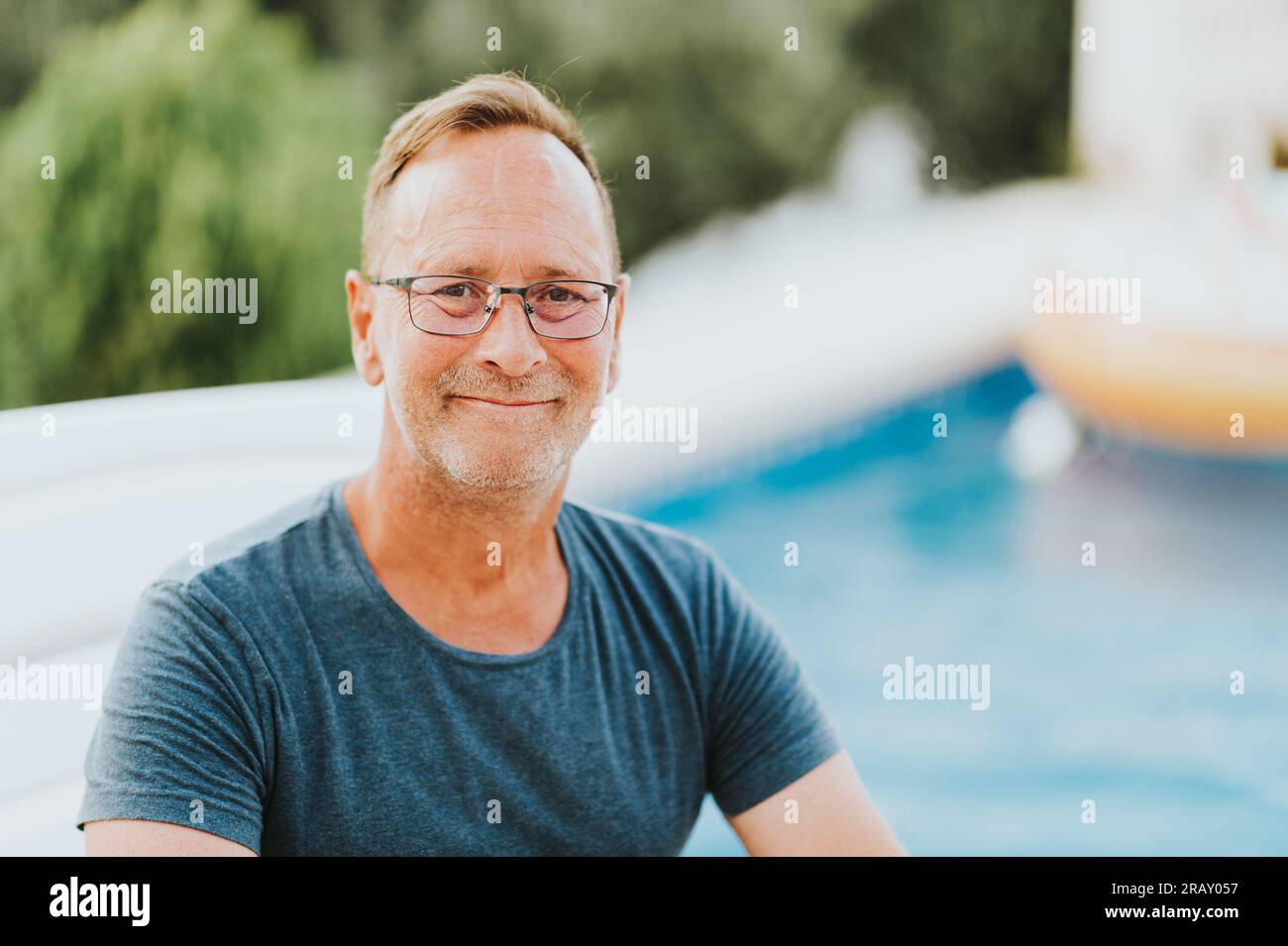 Ritratto all'aperto di un uomo di 50 anni che riposa vicino alla piscina Foto Stock