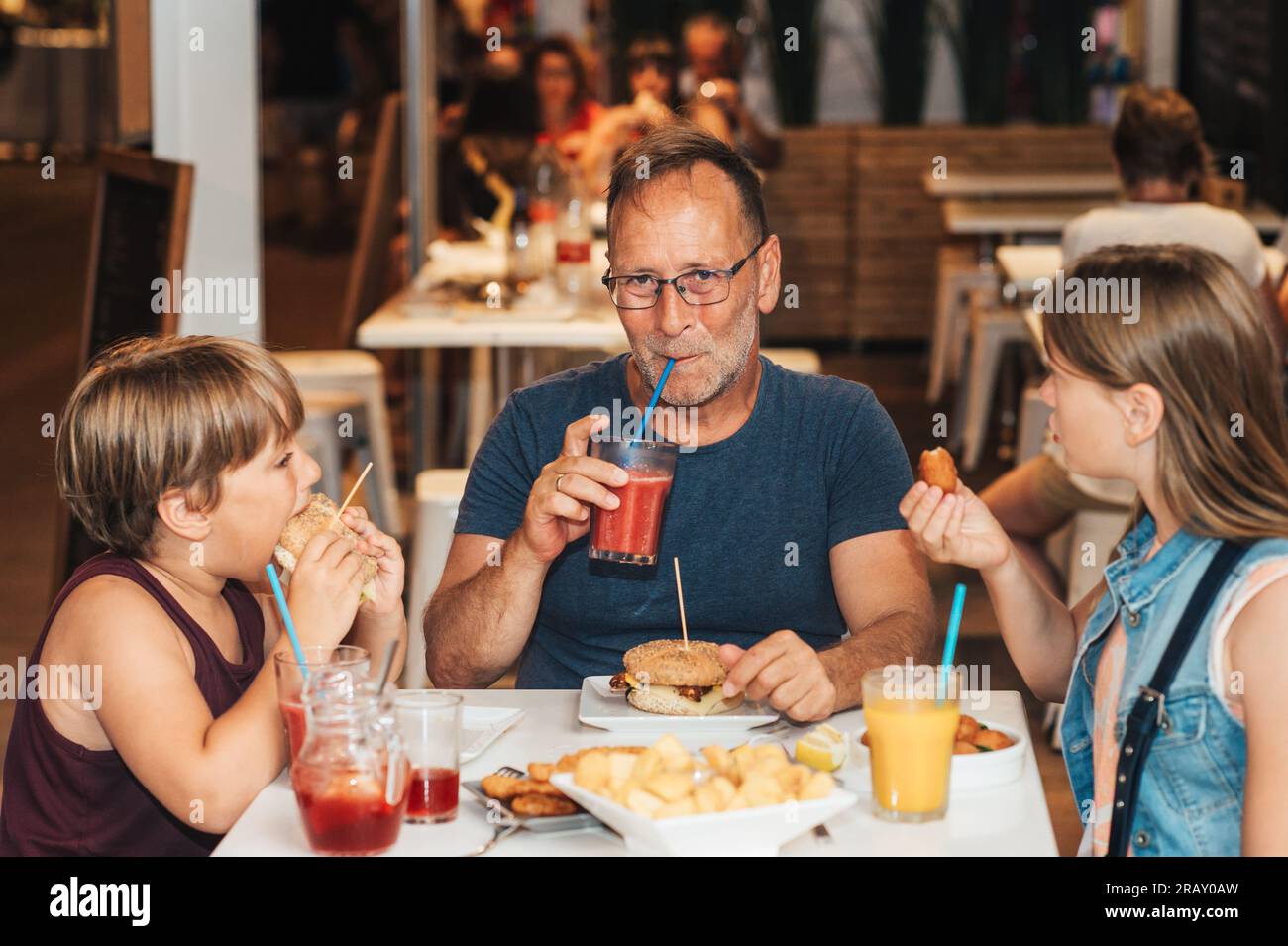 Felice famiglia con bambini nel ristorante all'aperto durante le vacanze estive in Spagna Foto Stock
