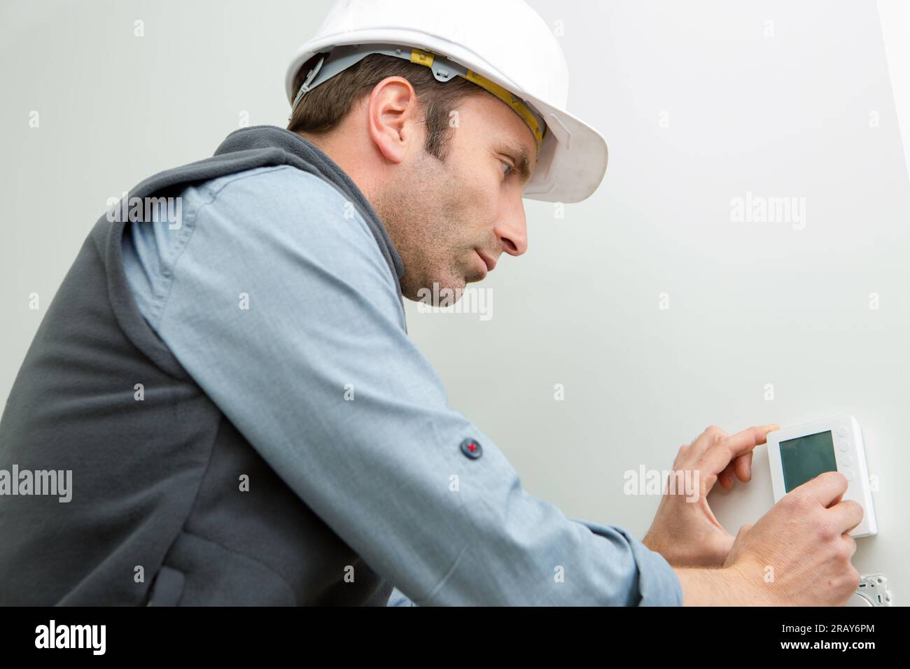 ritratto del lavoratore che installa l'isolamento termico di controllo Foto Stock