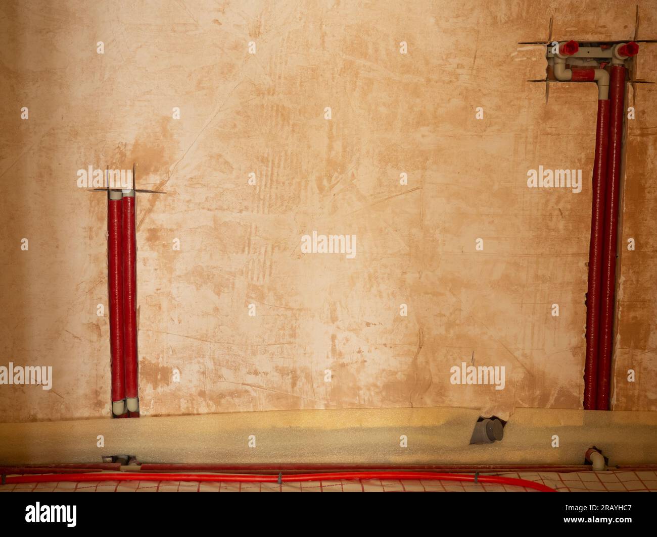 Installazione di tubi dell'acqua e del riscaldamento nell'appartamento. Interventi di manutenzione per impianti di riscaldamento e acqua. Concetto di impianto idraulico e ristrutturazione della casa. Foto Stock