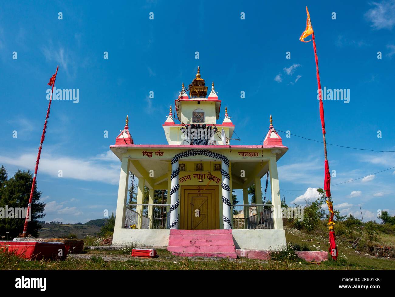 28 giugno 2023, Nagthat, Uttarakhand, India. Un tempio in un prato in cima a una collina con cielo blu dedicato a Nag Devta o al Signore Serpente (Una divinità indù). Foto Stock