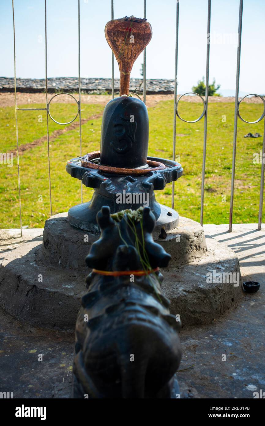 28 giugno 2023, Nagthat, Uttarakhand, India. Pietra nera Shiva Linga, simbolo sacro del Signore Shiva, accompagnato da un bue Nandi, che rappresenta la devozione Foto Stock