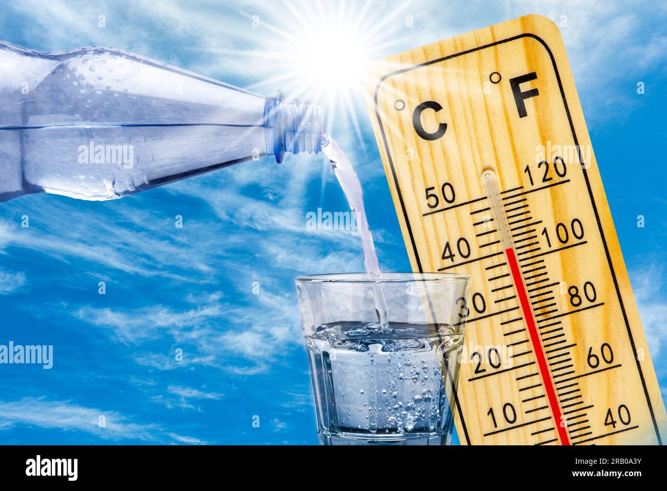 il termometro mostra la temperatura elevata nel calore estivo e bottiglia con acqua con bicchiere Foto Stock