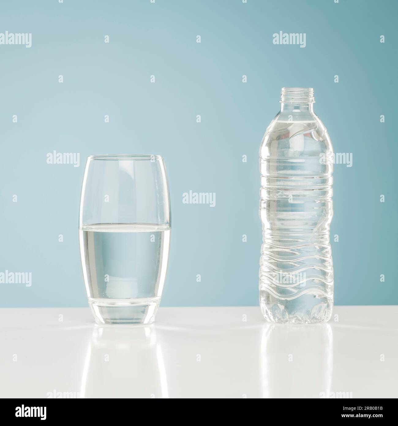Bicchiere d'acqua accanto all'acqua in bottiglia Foto Stock