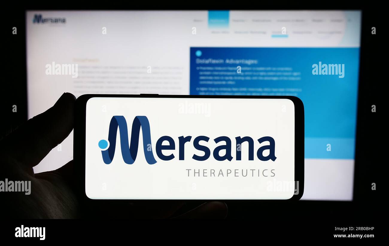 Persona che possiede uno smartphone con il logo della società biotecnologica statunitense Mersana Therapeutics Inc. Sullo schermo di fronte al sito Web. Concentrarsi sul display del telefono. Foto Stock
