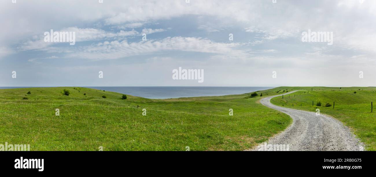 La strada da percorrere attraverso un paesaggio collinare Foto Stock