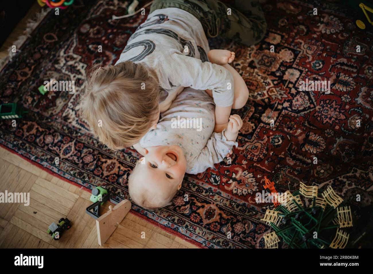 I fratelli si coccolano sul pavimento Foto Stock