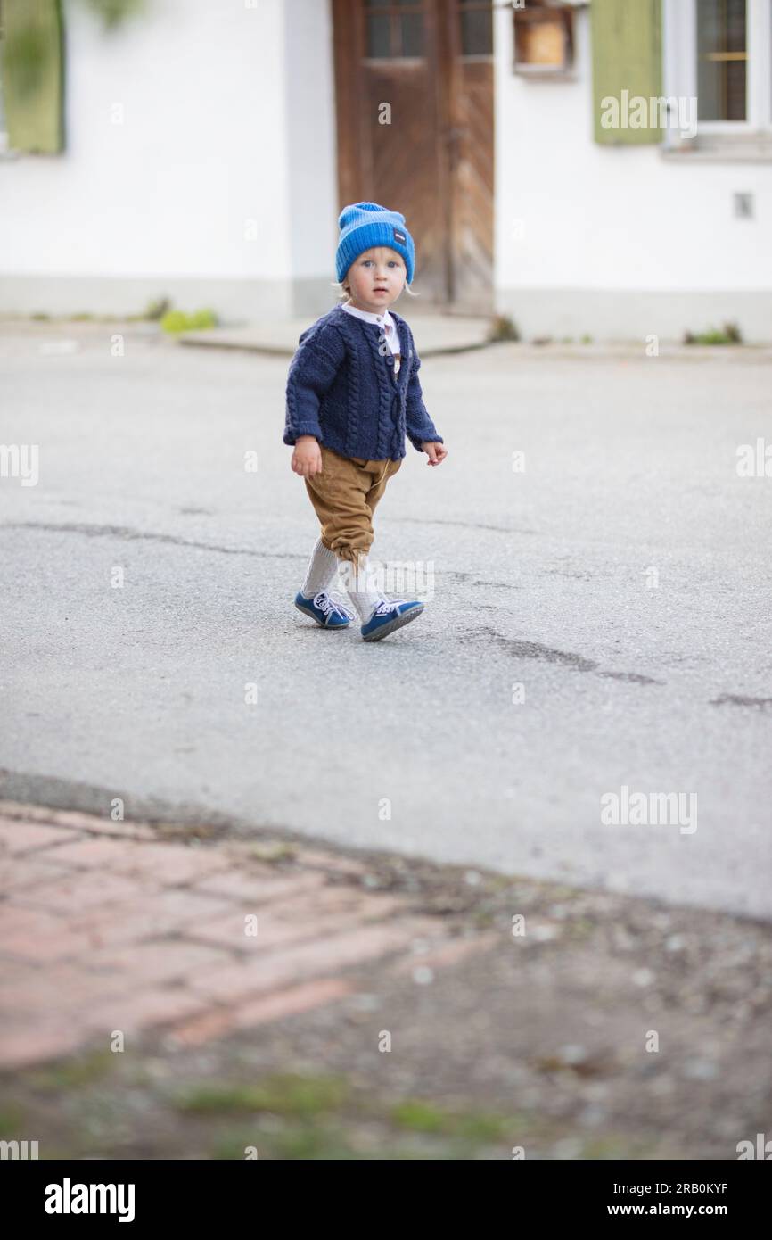 Bambino con pantaloni in pelle, cardigan e berretto in lana Foto Stock
