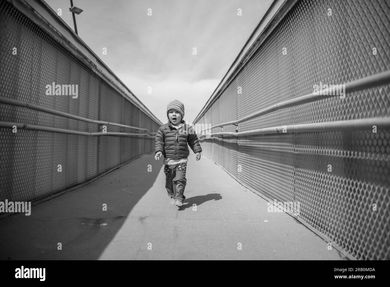 Ragazzo che corre sopra un ponte Foto Stock