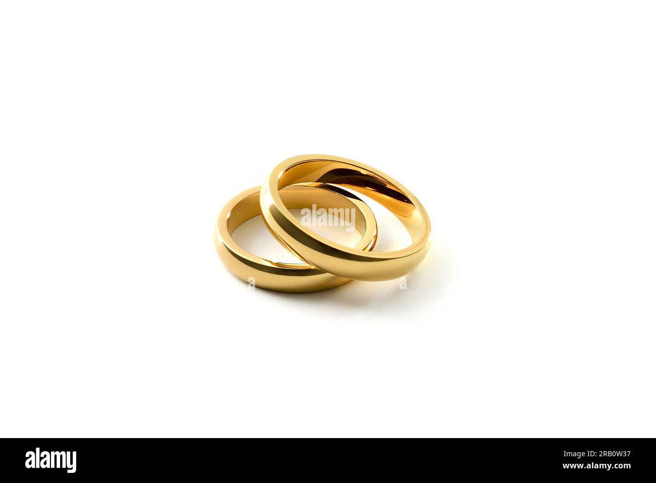 Dettaglio degli anelli di fidanzamento dorati sovrapposti su sfondo bianco isolato. Vista elevata. Foto Stock