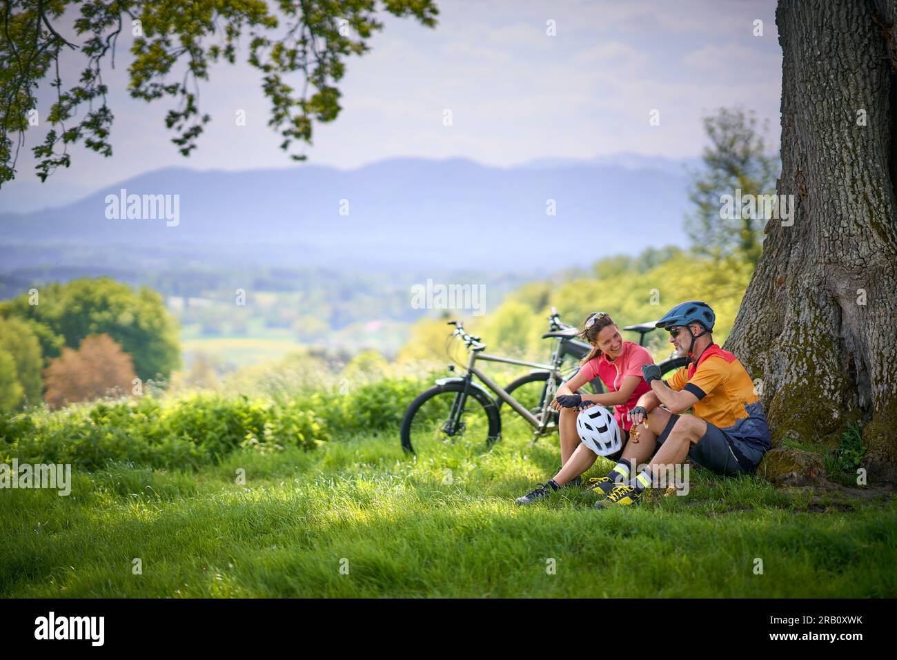 Coppia, uomo e donna che viaggiano in bici, riposo, pausa, trekking, e-bike Foto Stock