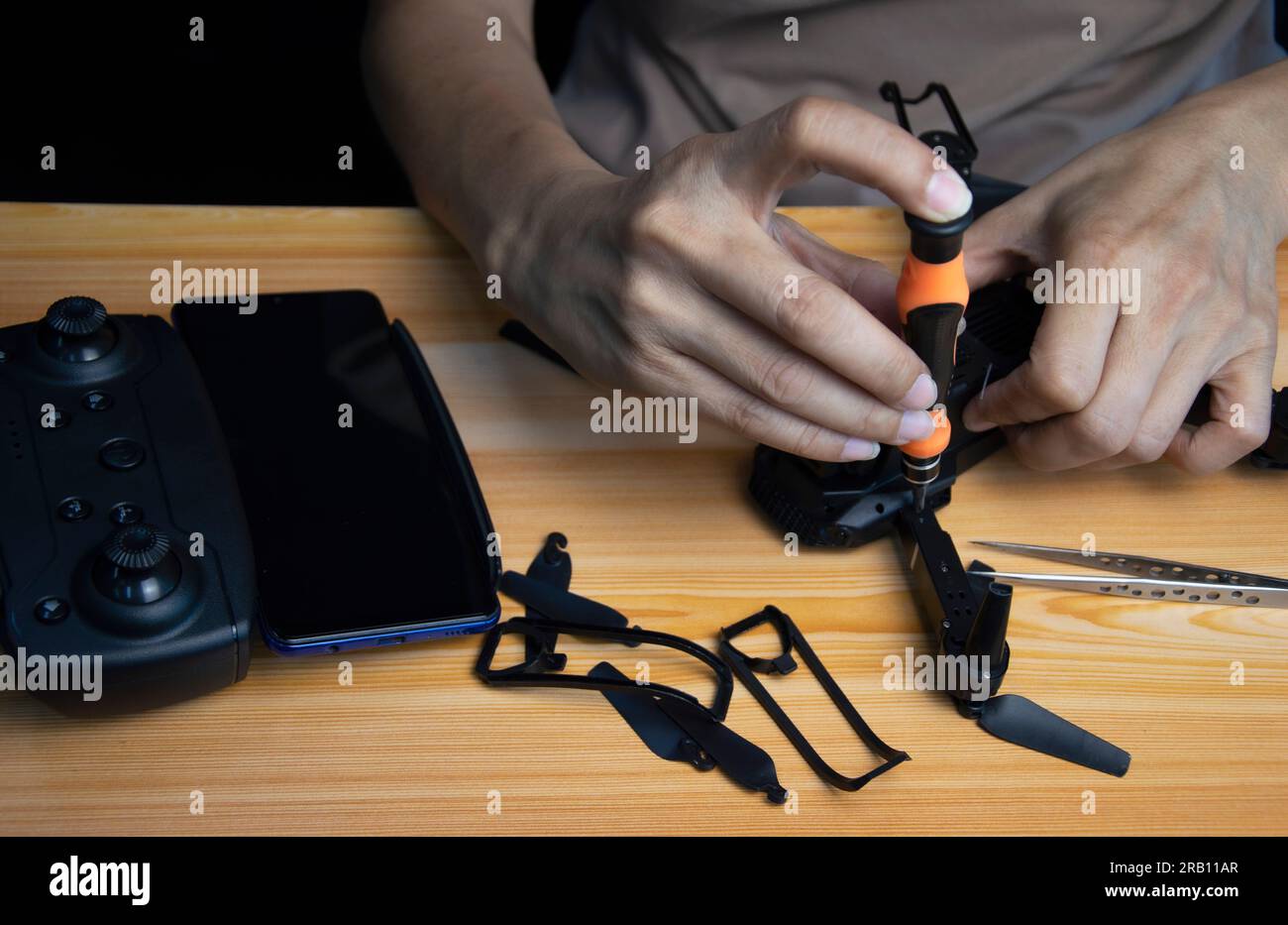 Riparazione di un piccolo drone per cacciaviti sul tavolo con vari attrezzi  in un'officina moderna Foto stock - Alamy