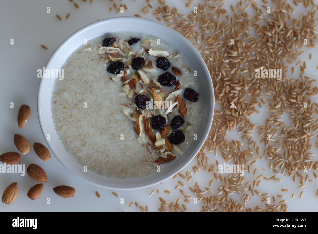 Porridge di grano Khapli. Porridge sano fatto di frumento farro rotto, bollito nel latte e servito con mandorle a fette e uva passa. Una versione del porridge Foto Stock