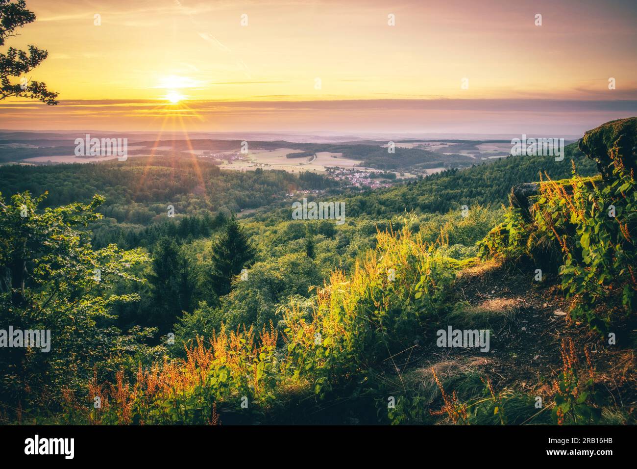 Splendida vista dalle cime di Pfälzerwald, pittoresca vista di un paesaggio con molta natura, colline, foresta e un'alba dai bellissimi colori caldi, Renania-Palatinato, Germania Foto Stock