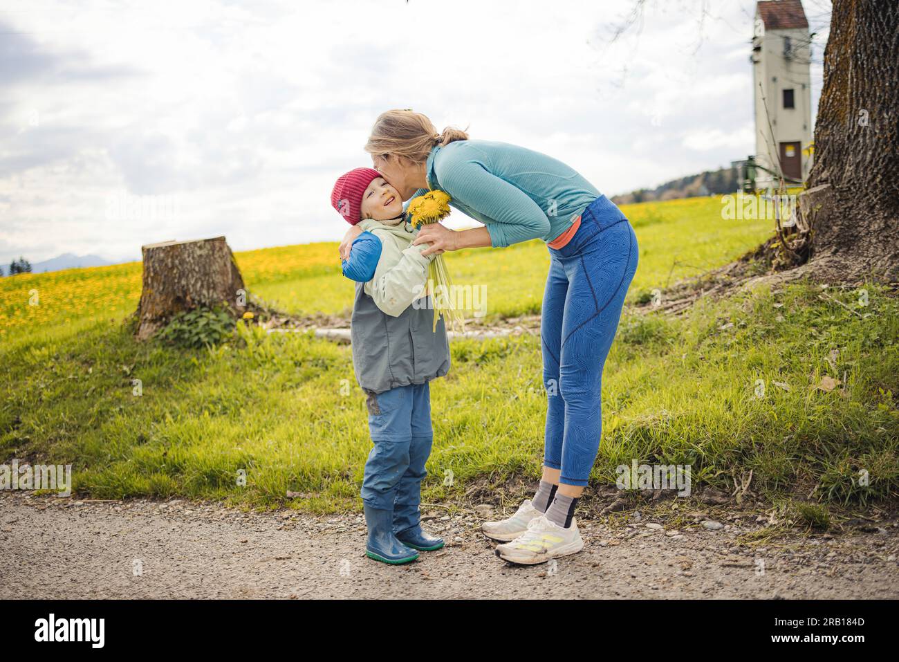 Il figlio presenta a sua madre un mazzo di fiori che ha raccolto da solo Foto Stock