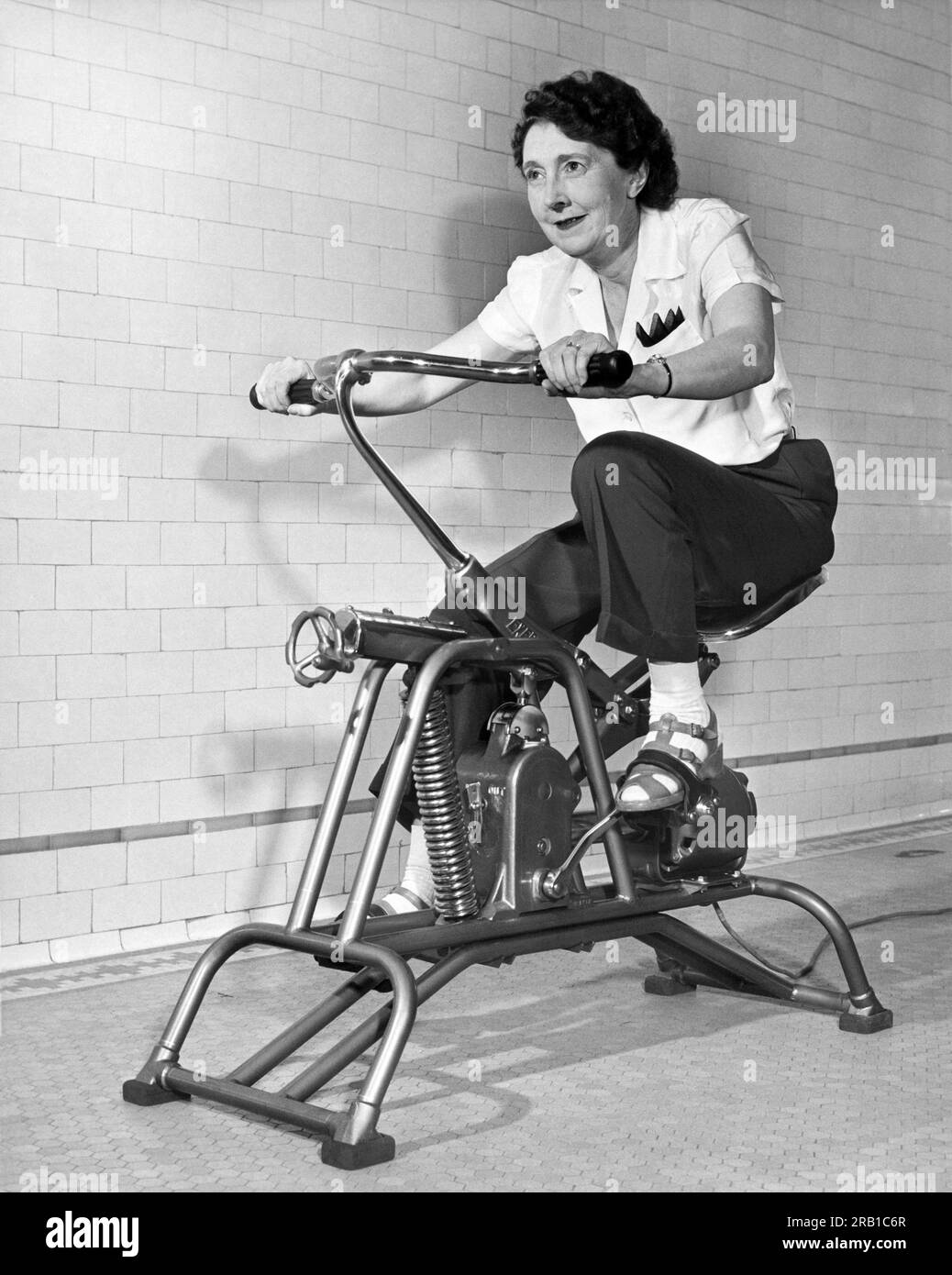 Stati Uniti: c. 1960. Una donna anziana pedala sul suo sforzo. Foto Stock