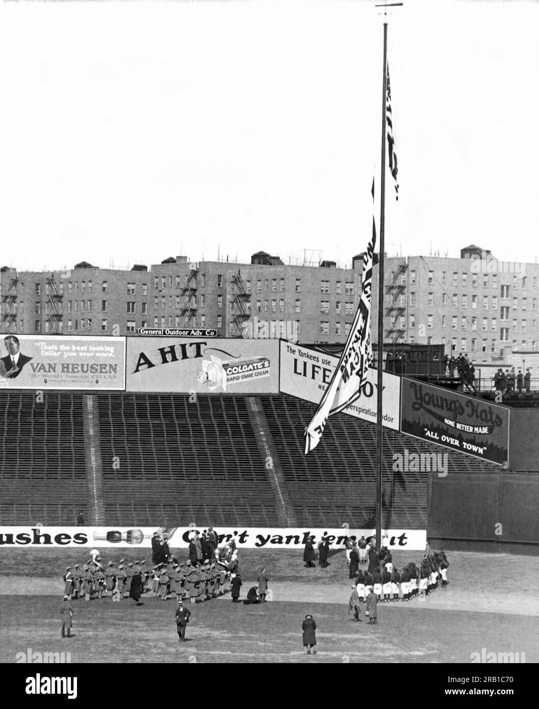 New York, New York: 1929. Il sindaco Jimmy Walker issa la bandiera del campionato mondiale di baseball per la prima partita casalinga della stagione allo Yankee Stadium di New York. Notare il pipistrello basale in cima all'asta della bandiera come una paletta resistente agli agenti atmosferici. Foto Stock
