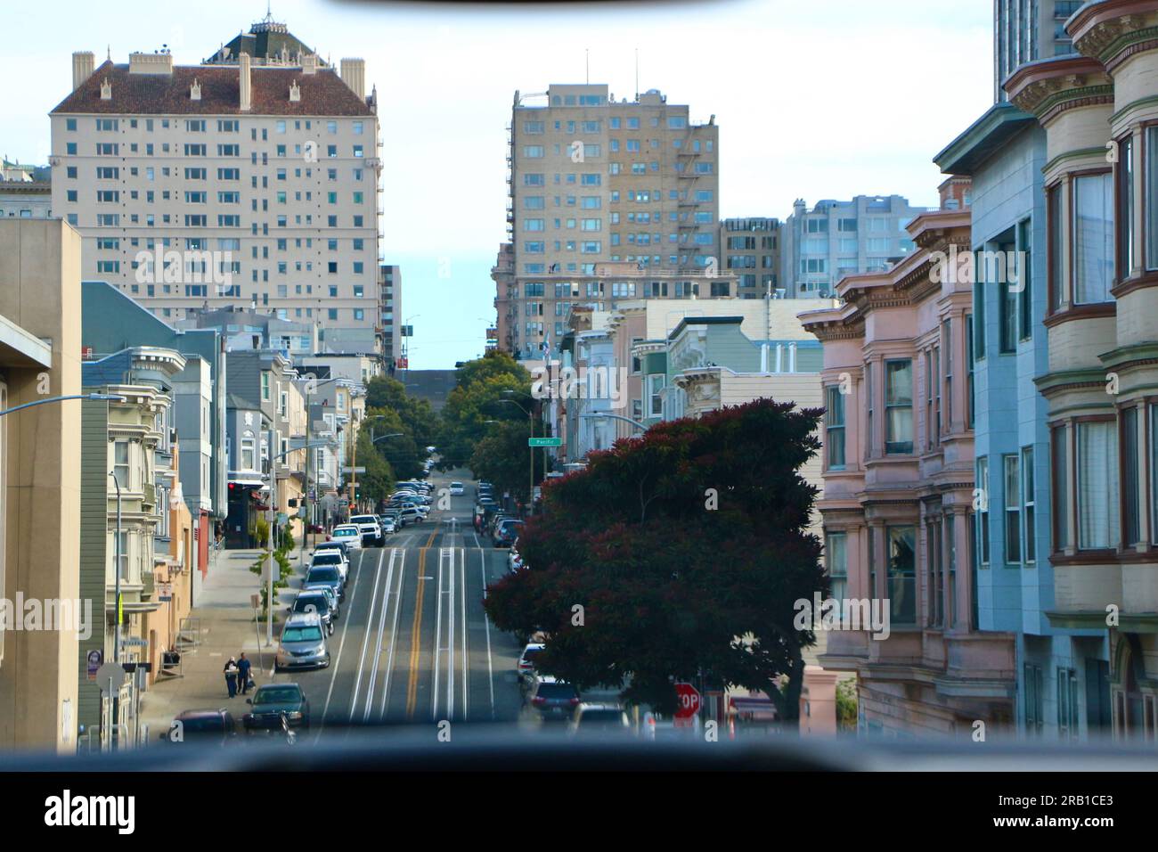 Vista di una tipica strada collinare con le indicazioni stradali di Pacific Avenue e i binari della funivia dall'interno di un'auto San Francisco California USA Foto Stock