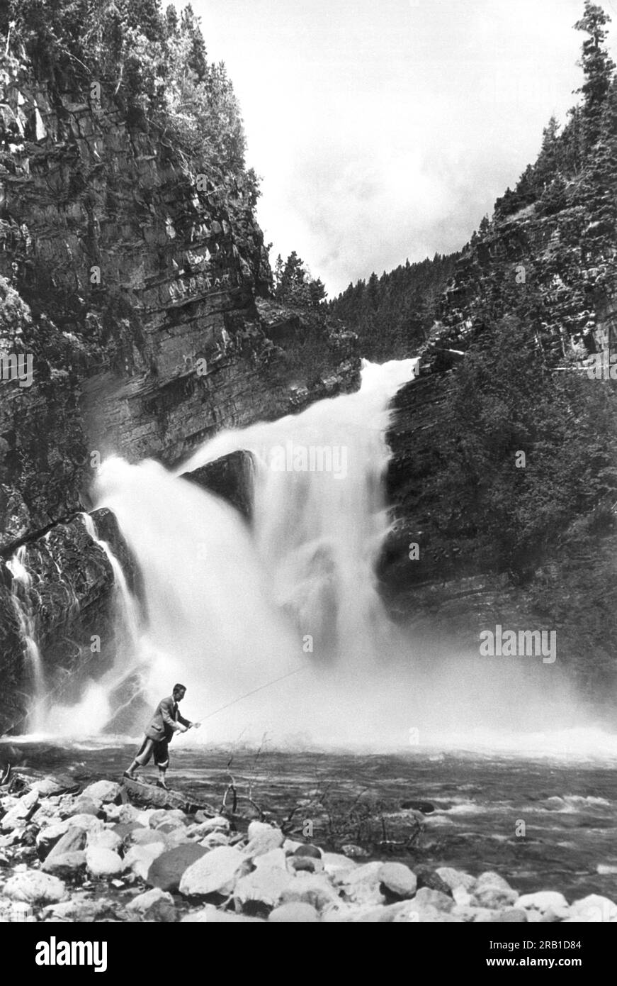 Waterton Lakes National Park, Alberta, Canada: 4 settembre 1929 Un uomo che pesca la trota sotto le cascate di Cameron. Foto Stock