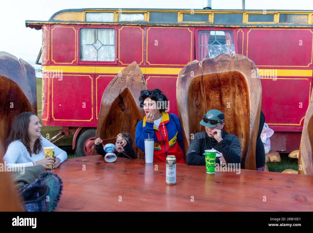 Gente che beve al Big Table del Theater Field Glastonbury Festival, Regno Unito Foto Stock